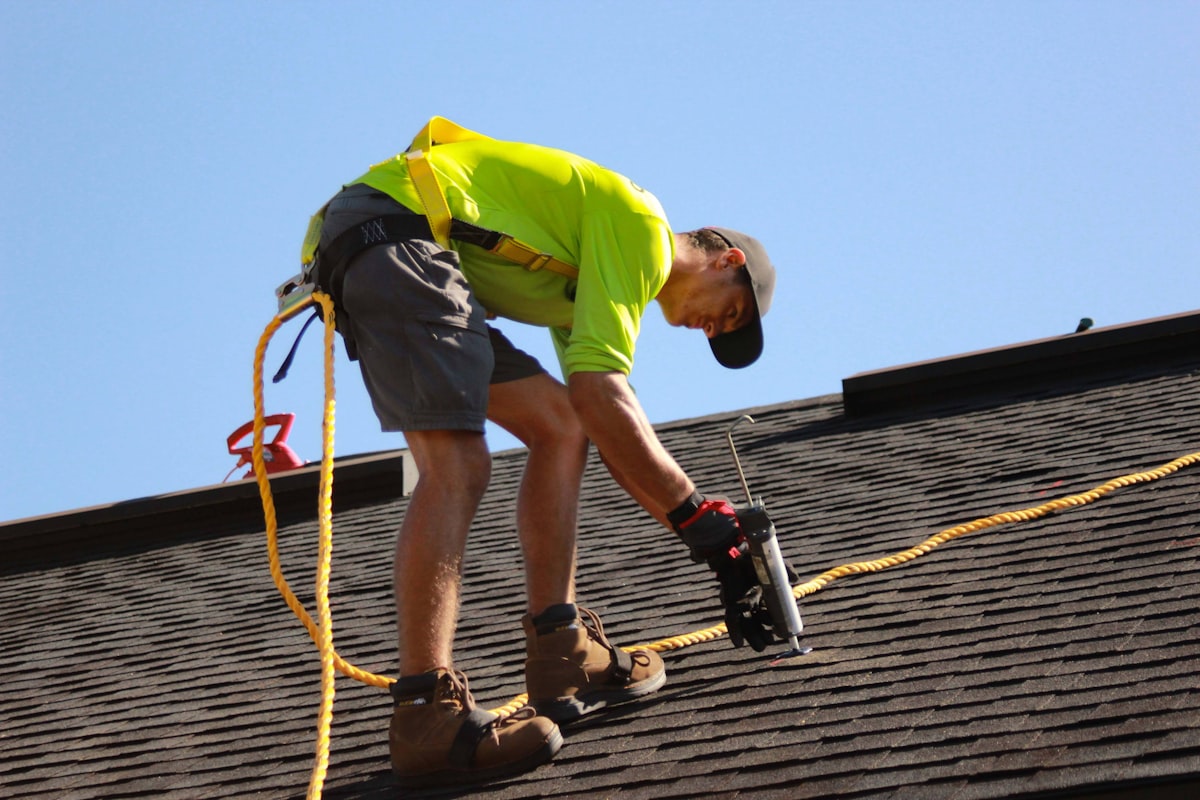 Roofer installing new shingles on a residential roof